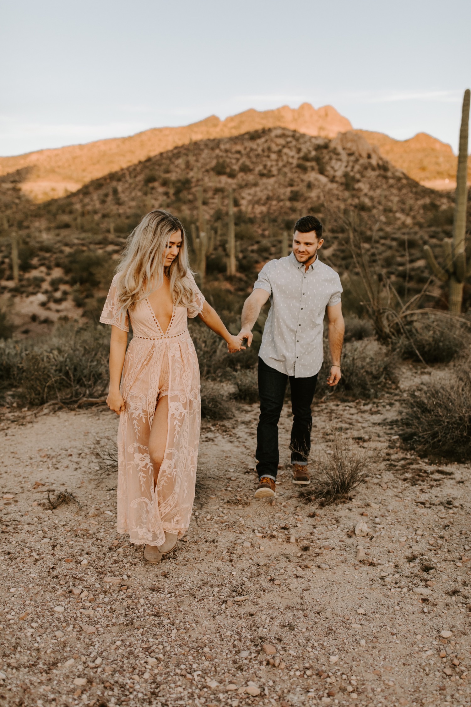 Walking through the desert hand in hand with a cute pink lace low cut dress