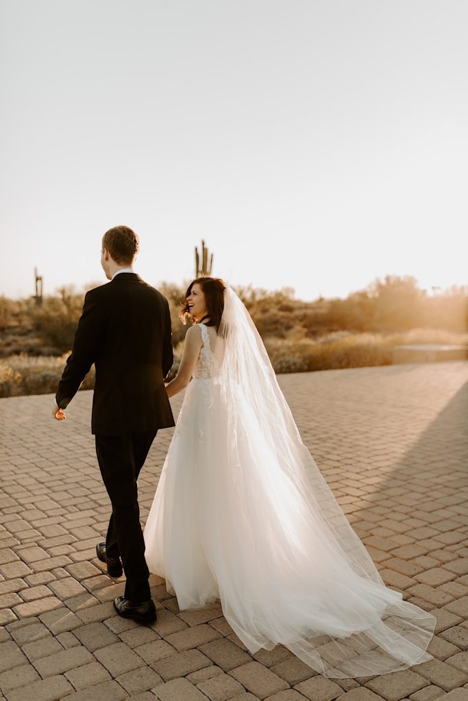 Bride and groom walking off in the sunset to the Arizona desert