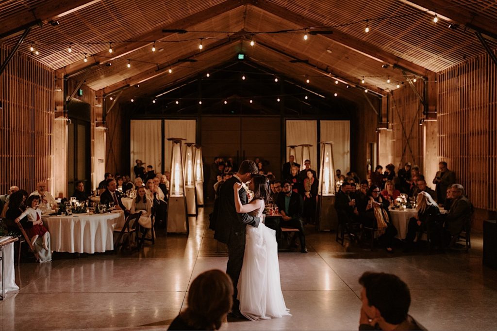 Bride and groom have their first dance lit by twinkle lights