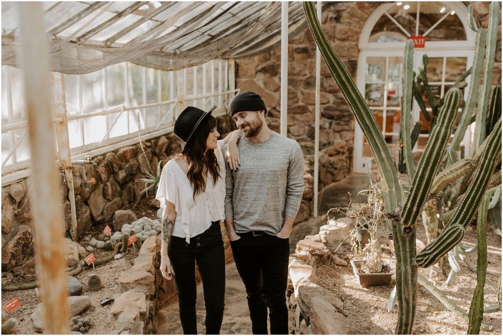 engaged couple posing for photos in Boyce Thompson Arboretum surrounded by cactus