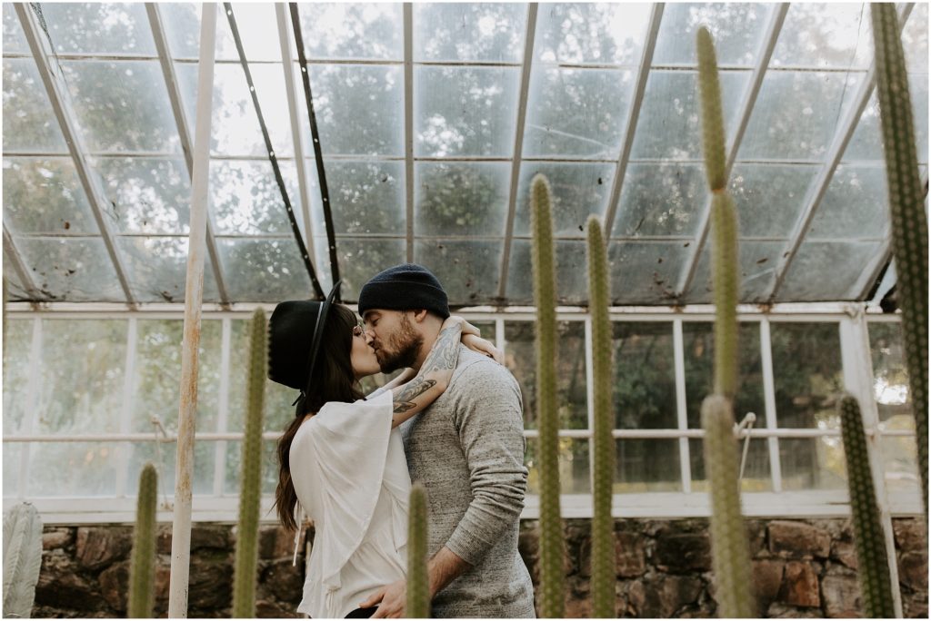 engaged couple kissing in Boyce Thompson Arboretum surrounded by cactus