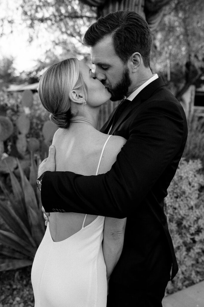 Black and white wedding photo of newlyweds sharing a kiss on their wedding day in Scottsdale